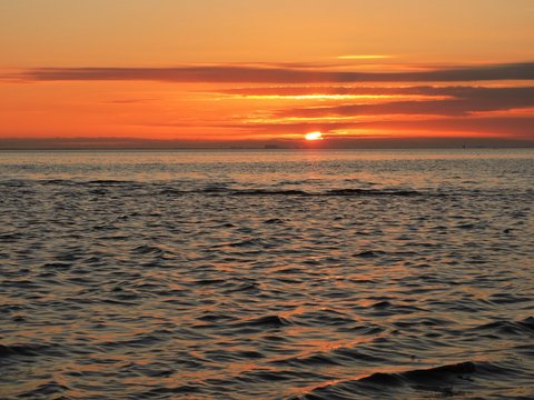 Fototapeta close-up of sun setting on the bay