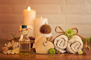 Fototapeta na wymiar Spa and wellness setting with oil, candles and towels