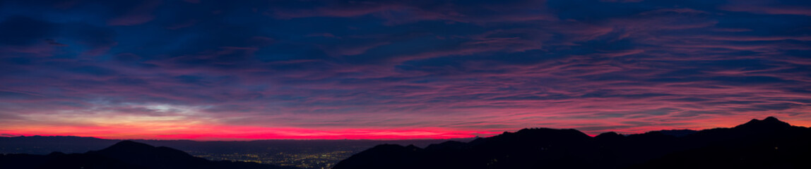 Fiery sunset from mountain pick in a cloudy evening. Fall season. Orobie mountains. Italian Alps.