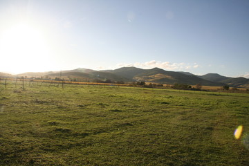 Fototapeta premium Late sun on field and mountain