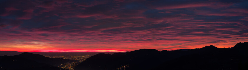 Obraz na płótnie Canvas Fiery sunset from mountain pick in a cloudy evening. Fall season. Orobie mountains. Italian Alps.