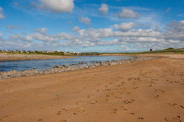 Sandy Beach with small river and traditional stone arched bridge in Lehinch on the Atlantic Coast in the West of Ireland