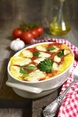 Polenta baked with tomato and cheese.