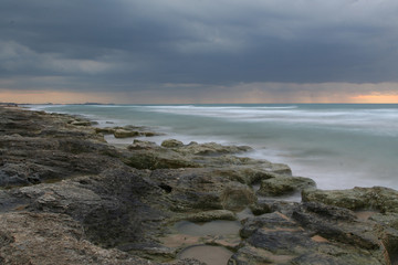 Fototapeta na wymiar Sunset in Automn on the beach rocks long exposure