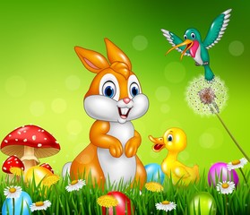 Obraz premium Easter bunny with decorated Easter eggs in a field