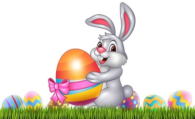 Easter bunny with decorated Easter eggs in a field