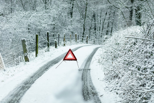 Stra&szlig;e nach starken Schneefall mit Warndreick.