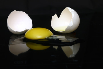 A broken egg on a black background