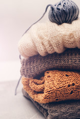 warm knitting clothes and clews of yarn on white background