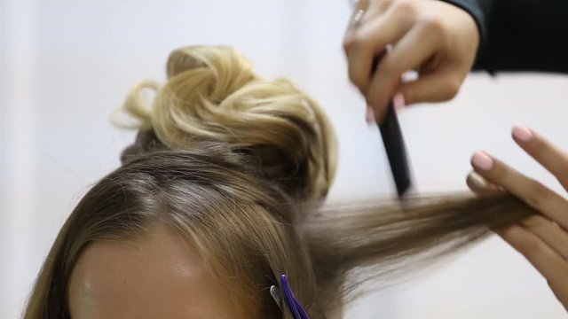 Professional hairdresser making bouffant at hair strands and creating volume, Close-up hairstyle