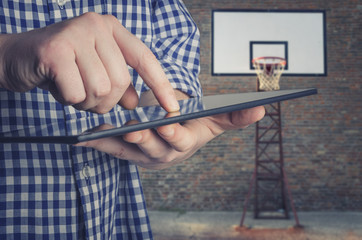 Basketball coach using a digital tablet on the basketball court