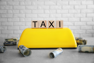 Cubes with word taxi and roof sign on brick wall background