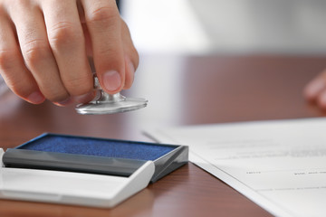Notary public pressing stamp into ink pad