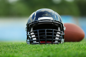 Rugby helmet with ball on field