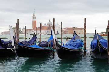 Fototapeta na wymiar Gondolas moored in canal of Venice