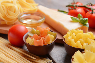 Different kinds of pasta on wooden background