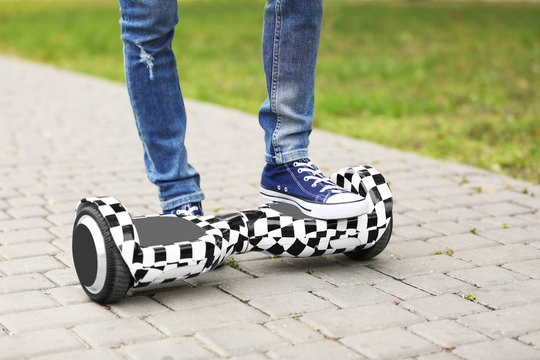 Teenager boy using hoverboard in park