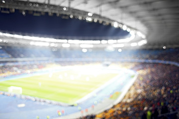 Fototapeta na wymiar Panoramic view of modern stadium during football match, blurred background