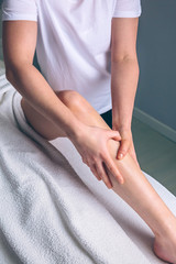 Fototapeta na wymiar Close up of female therapist hands doing lymphatic drainage massage on legs of woman in a clinical center. Medicine, healthcare and beauty concept.