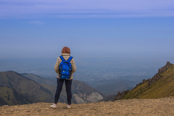 Fototapeta premium Sport woman are standing at Talgar pass and looking on the city,