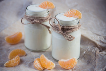 Organic yougurt with fresh tangerine in glass jars