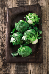 Fresh green broccoli in wood bowl over rustic wooden background