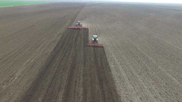 aerial view of a tractors plowing agriculture field
