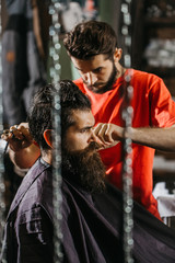 Obraz premium Barber cuts hair to man