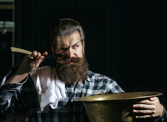 Bearded man shaves with razor
