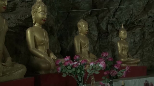 Zoom in to a row of Buddha images. A small cave occupied by a Monk for 30yrs. Artificial lighting is not allowed. The cave is lit by a small hole in it's roof and a few recessed lights.