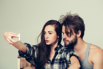 serious couple makes selfie on phone