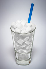 Glas voll mit Würfelzucker - Symbol für Zucker als versteckter Krankmacher. 