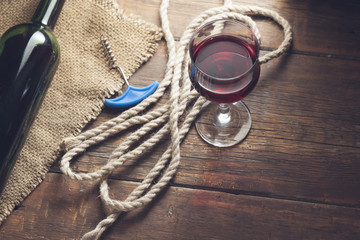 Pouring red wine glass against wooden background