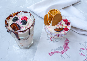 Delicate milk dessert with berries and biscuits in glasses on Valentine's Day.