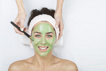 Young woman in a spa with algae facial mask. Woman in spa salon