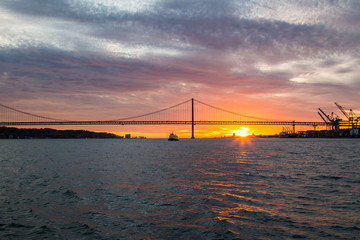 Fototapeta premium Panoramic views of the Tagus River, Bridge April 25 Lisbon and port at sunset from ship, Portugal.