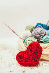 Fototapeta na wymiar Knitted heart symbol and ball of yarn