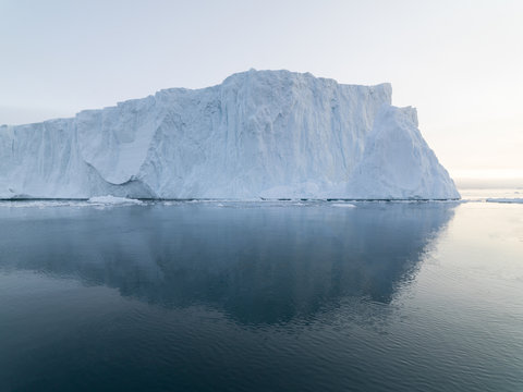 Arctic Icebergs Greenland in the arctic sea. You can easily see that iceberg is over the water surface, and below the water surface. Sometimes unbelievable that 90% of an iceberg is under water