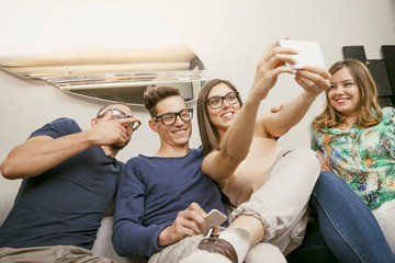 group of friends on couch takes a selfie in a funny way