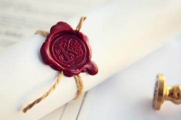 Tied scroll with old notarial wax seal and stamp on table
