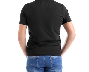 Obraz premium Young man's back view in blank black t-shirt and blue jeans, casual apparel mockup for design and branding
