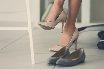 Woman changing shoes in office at work