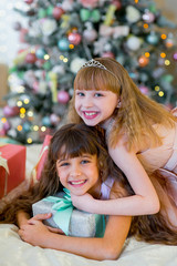 Fototapeta na wymiar Two adorable girls with Christmas gifts