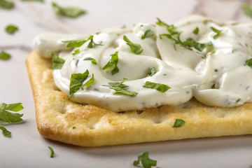 Thin crispy crackers with cream cheese and parsley