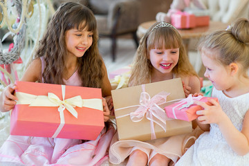 Three young happy girls with Christmas gifts