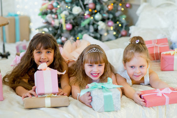 Three young happy girls with Christmas gifts