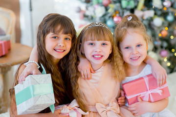 Three young happy girls with Christmas gifts