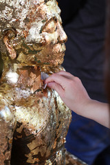 Attach gold leaf on Buddha statue , Buddism make merit by using gold leaf to worship the buddha