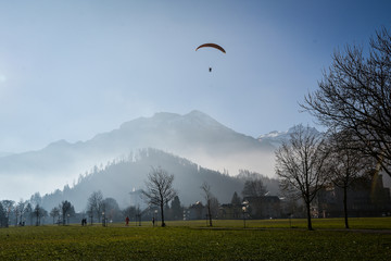 Paraglider flying over mountains in Interlaken