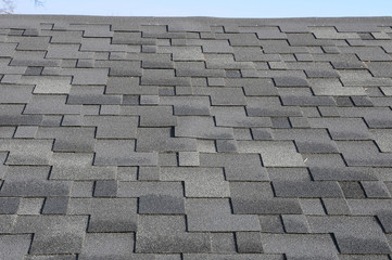 The roof shingles as a background or texture. Close up view on Asphalt Roofing Shingles Background. Roof Shingles - Roofing. Bitumen tile roof.